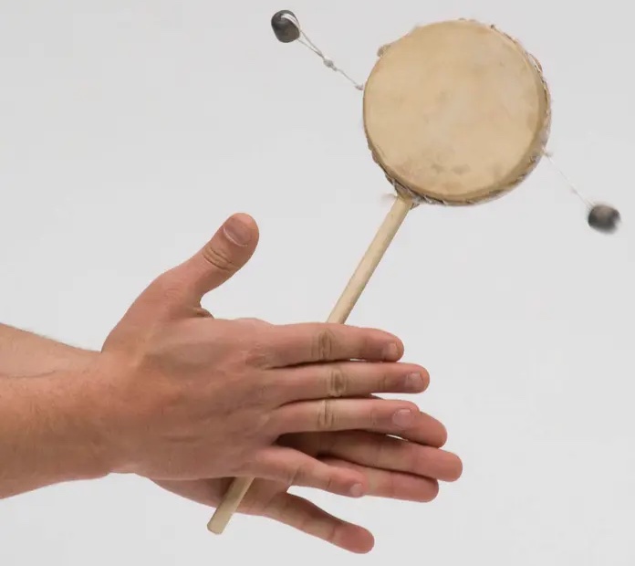 Houten rammeltrommel met roterend handvat en hangende slagbolletjes